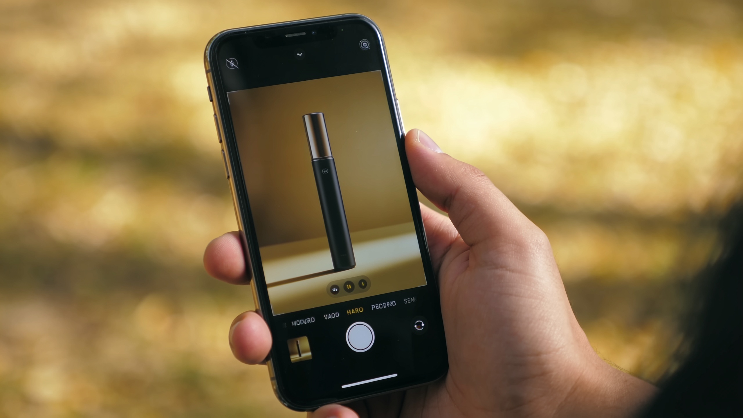 Hand holding smartphone displaying a vertical product demo