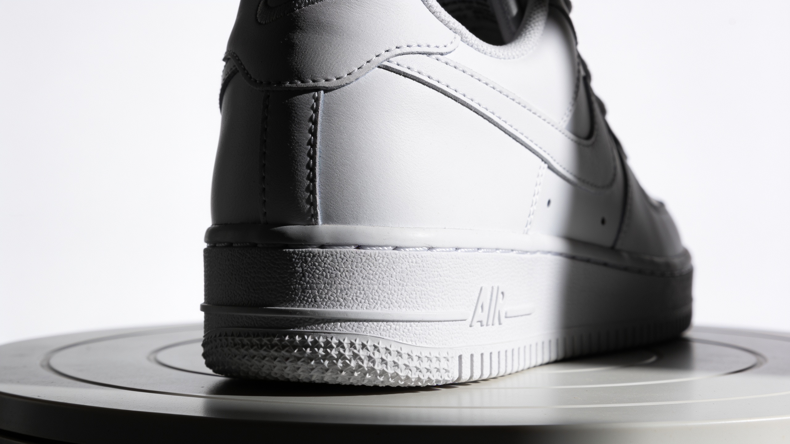 Minimal studio sneaker close-up on a rotating platform with rim light