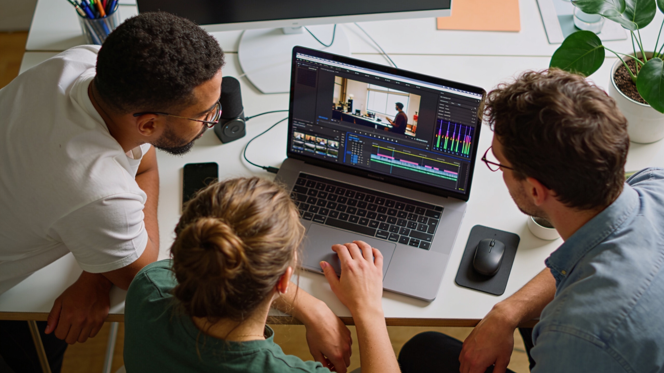 Team editing a short-form ad with audio stems on a laptop