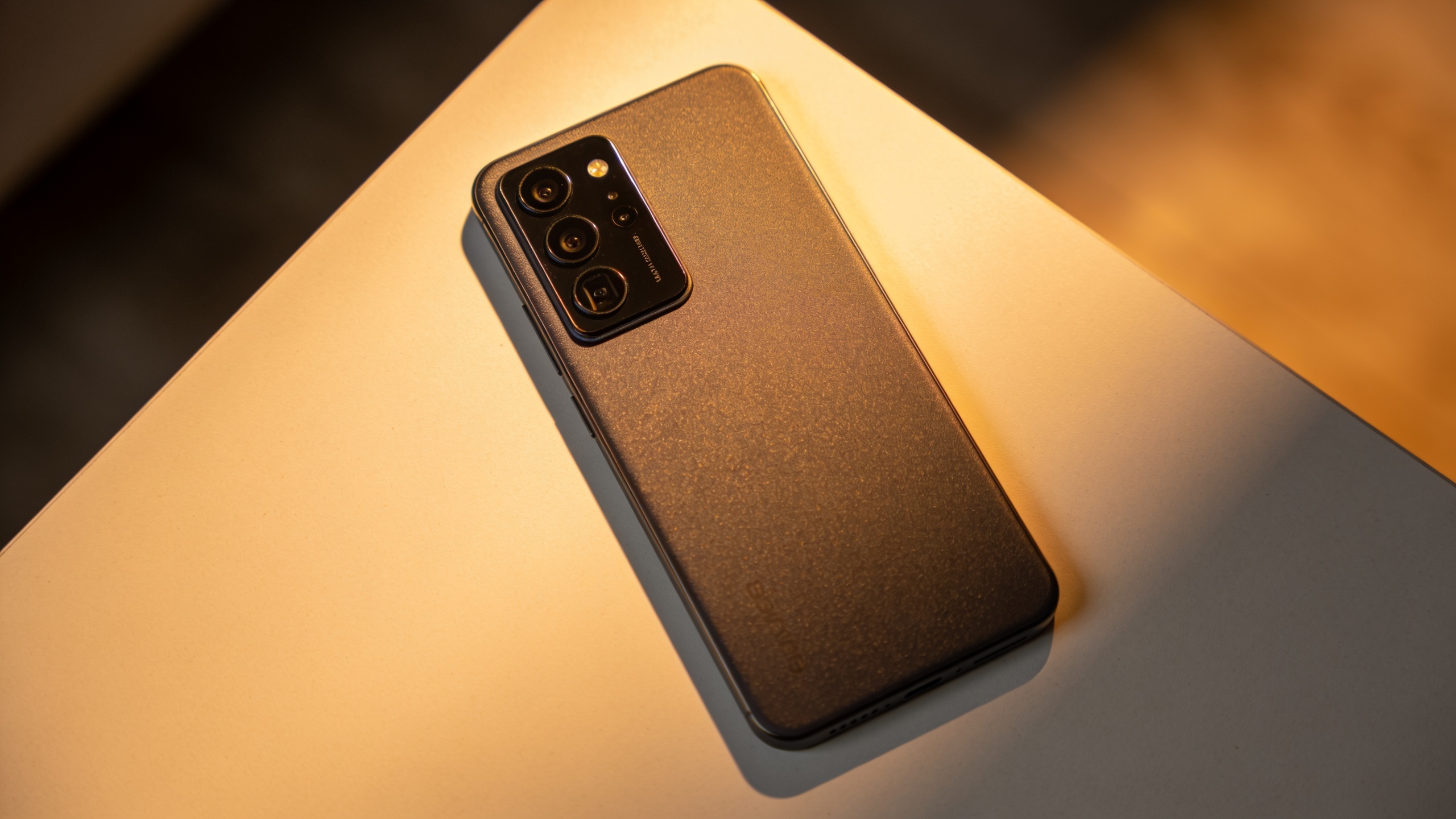 Smartphone on table with warm rim light in portrait orientation